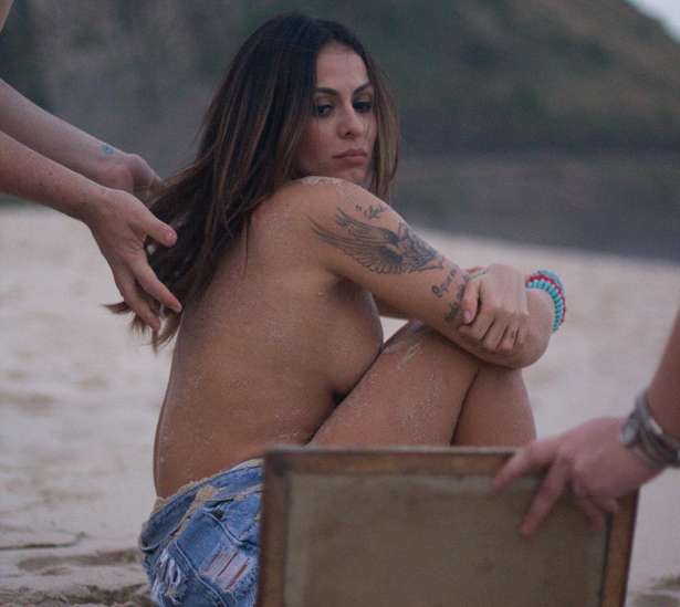 Alinne Rosa faz topless em sessão de fotos na praia.